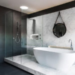 Mustavalkoinen kylpyhuone marmoripöydällä ja seinäpaneelilla