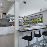 Design of a white kitchen in the interior of a spacious house with a terrace