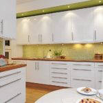 Design of a white kitchen in the interior with light green
