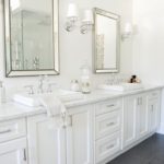 Baltas vonios kambarys su pilkomis blizgančiomis plytelėmis ant grindų