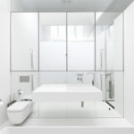 Banheiro branco com uma parede de espelho
