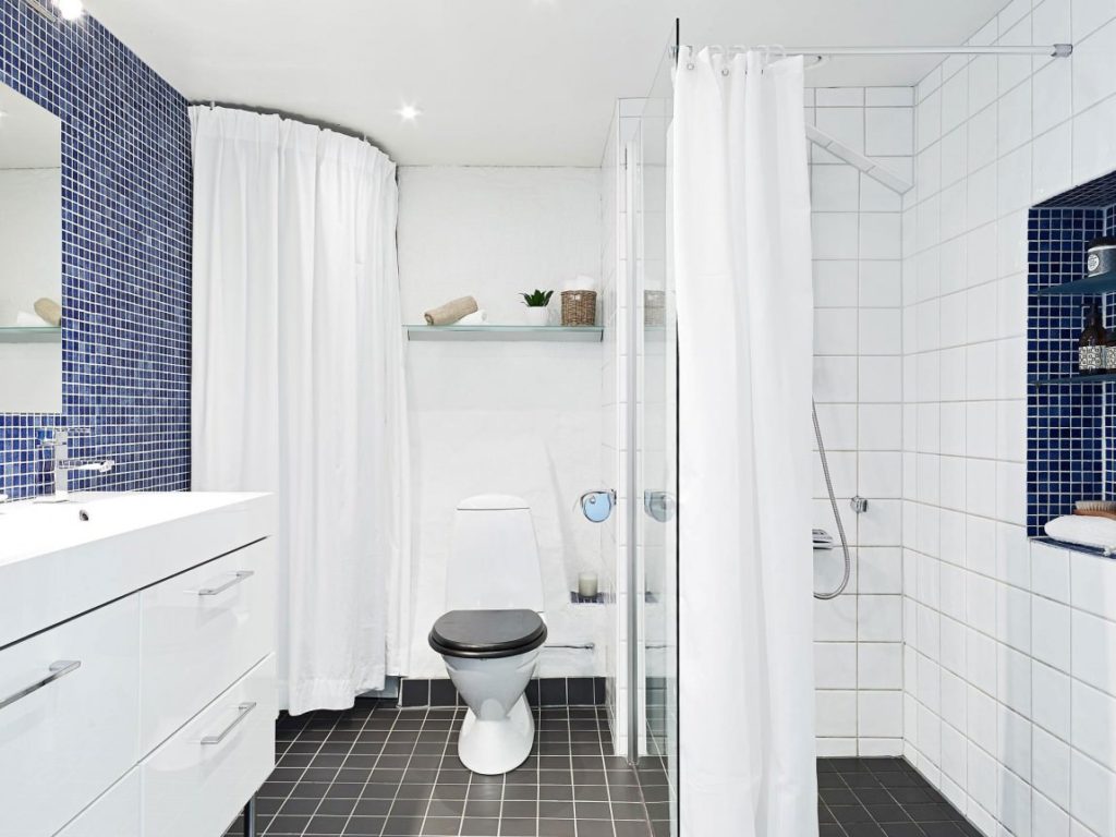 Banheiro branco estilo escandinavo e azul.