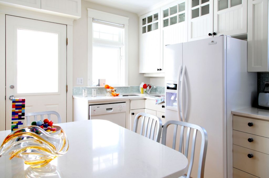 White refrigerator in the interior of a white kitchen