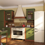 White refrigerator in the interior of the kitchen with a green set