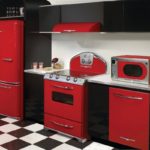 A konyha belsejében található hűtőszekrény piros és fekete színű