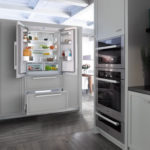 Hűtőszekrény a konyha belsejében egy világosszürke szekrényben