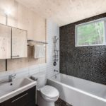 Mozaīka vannas istabas kompozīcijā ar flīzēm un koka paneļiem