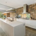 Virtuves siena, kas izgatavota no dekoratīvā akmens, paveras uz terasi