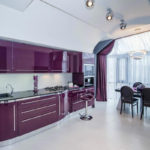 Bucătărie violetă cu scaune negre.