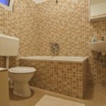 Différentes nuances de carreaux beiges pour la conception de la salle de bain.