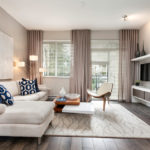 Svetlo béžová dekorácia obývacej izby s pohovkou a horizontálnymi žalúziami.