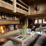 Sala de estar estilo chalé com painéis de madeira e móveis de madeira maciça
