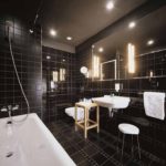 Moderne design badkamer zwarte tegels en wit sanitair