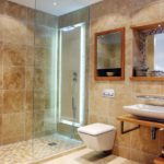 Shower column with transparent door in a beige bathtub