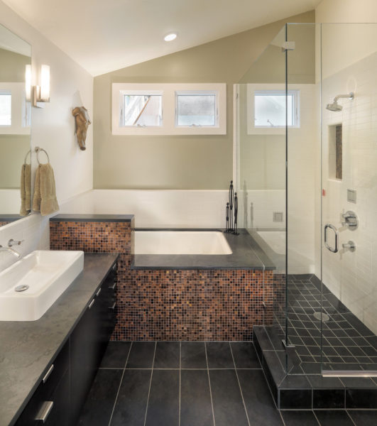 Stilīga smilškrāsas vannas istaba ar melnu grīdu