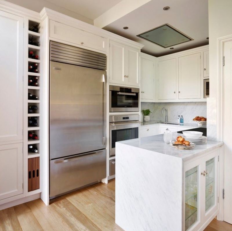 Hvidt køkken og køleskab i rustfrit stål