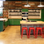 Ghế quầy bar màu đỏ và tủ bếp màu xanh lá cây