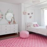 Rožinis kilimas kambaryje su baltomis sienomis