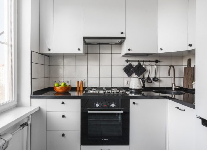 Црна рерна у белој кухињској гарнитури