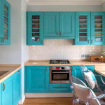 Turquoise kitchen with a square white ventilation duct
