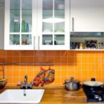 Orange flisebelagt forklæde i køkken i panelhus