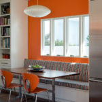 Oranža siena aiz dīvāna virtuvē-viesistabā