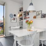 White dining table in the kitchen with a balcony