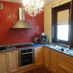 Diagonal lægning af røde fliser på køkkenvæggen