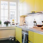 Gaiša virtuve ar dzeltenām fasādēm
