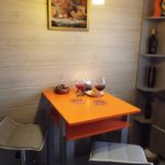 Kompakti pöytä oranssilla työtasolla Hruštšovin keittiössä