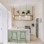 Žalia baro kėdės baltoje virtuvėje