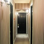 Pinstripe tapetes koridora interjerā