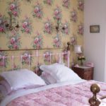 Pink flowers on the wallpaper in the bedroom