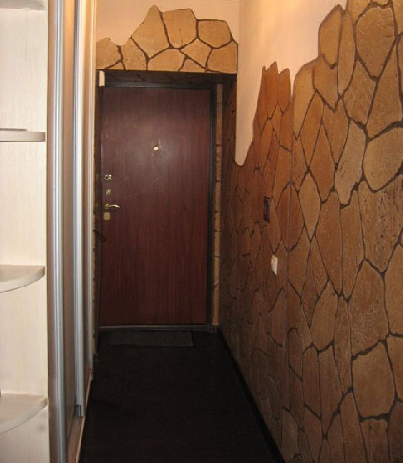 Natural stone in the design of the walls of a small hallway
