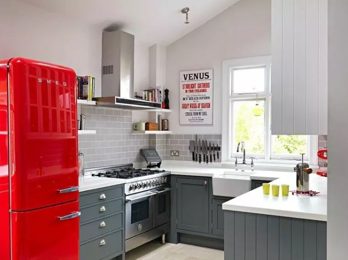 Raudonas šaldytuvas privataus namo virtuvės interjere