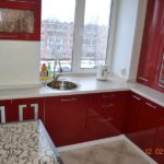 Køkken i en højhus i rødt og med en vask ved vinduet
