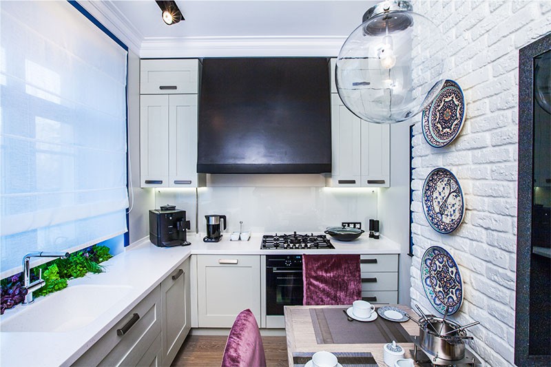 Interiér bílé kuchyně s plynovým ohřívačem vody
