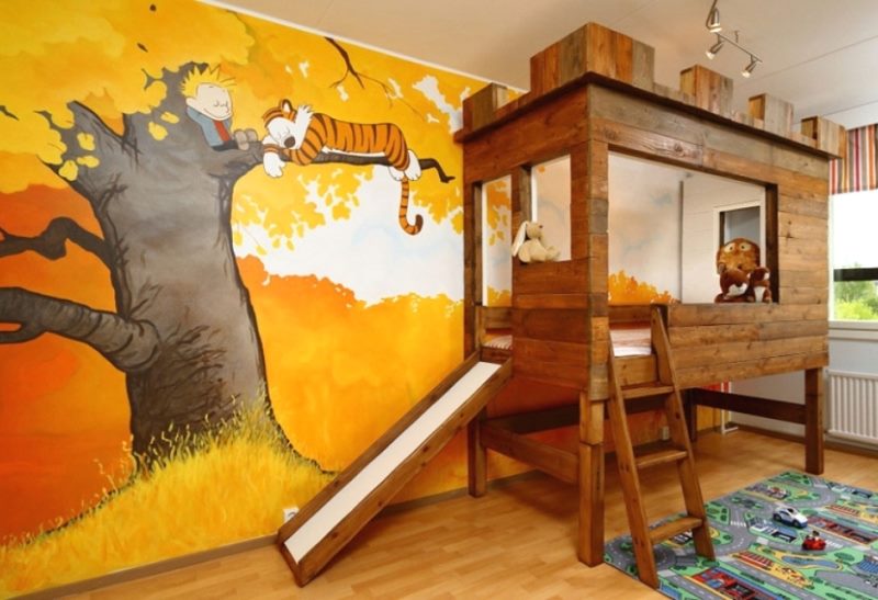 Dřevěná postel v dětském pokoji s obrázkem na zdi
