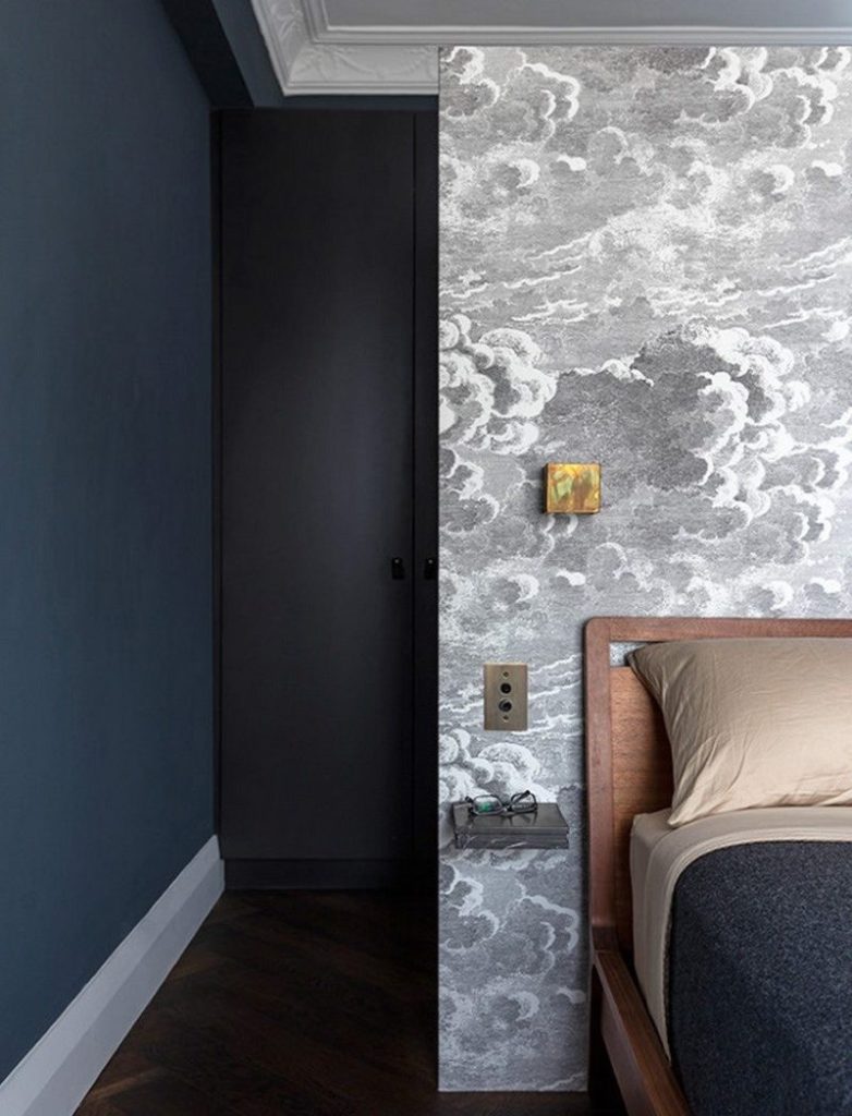 The combination of dark walls with gray wallpaper print