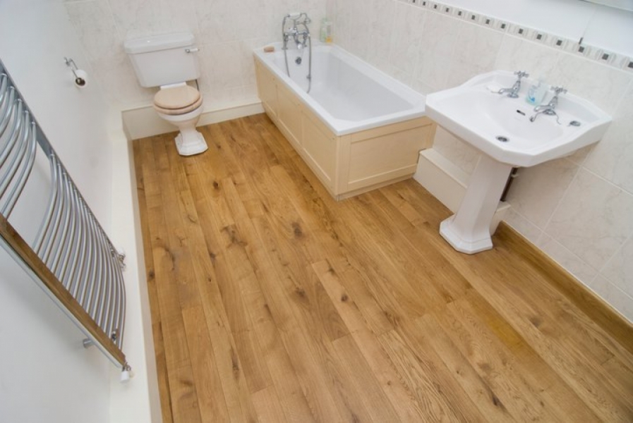 Wooden bathroom floor with white walls