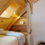 Plafonul din lemn deasupra patului mansardei