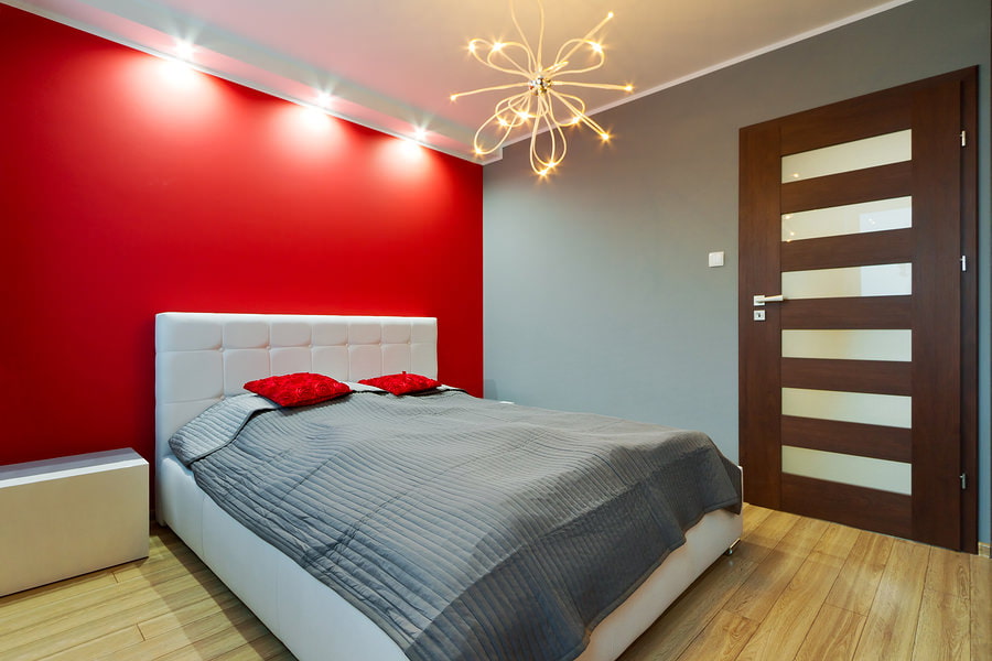Peretele roșu în interiorul unui dormitor mic
