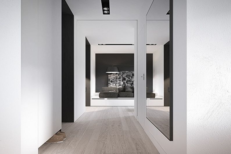 Un gran mirall a la paret del passadís a l'estil del minimalisme