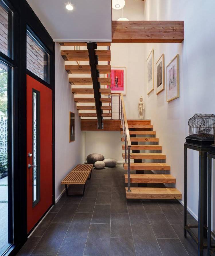 Pequeno hall de entrada com escadas para o segundo andar de uma casa particular