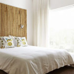 Bamboo headboard in bedroom with large window