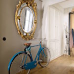 Bicycle under a round mirror in a gold frame