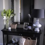 Black dressing table in front of a wall mirror