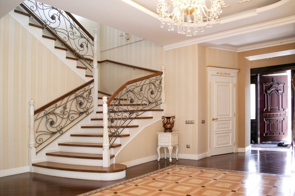 Amplio hall de entrada con escalera de estilo clásico.