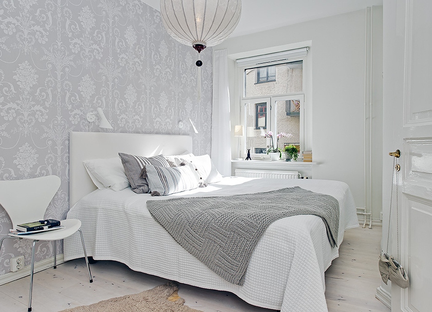 Interior of a small bedroom in gray and white colors