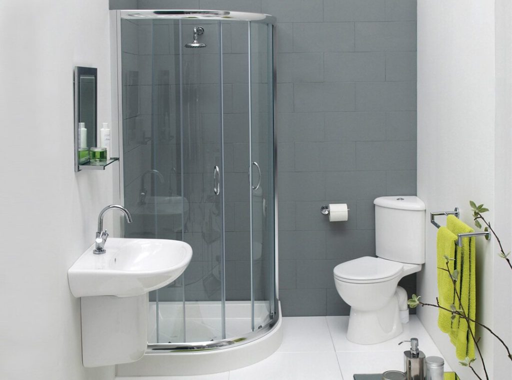 Cutie de duș lângă un perete gri într-o baie compactă